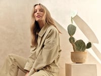 Woman sitting in a beige outfit 