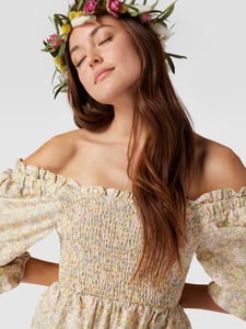 Vrouw met bloemenkrans draagt een romantische boho top 