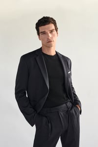 Mann mit schwarzem Anzug und schwarzem T-Shirt