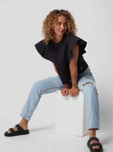 Vrouw in trendy straight jeans met scheuren en cut-outs
