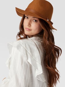 Vrouw met witte blouse en bruine hoed