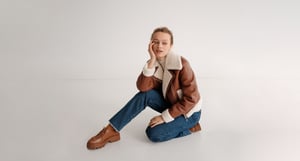 Kampagne Modern Heritage sitzende Frau mit Shearling-Jacket 