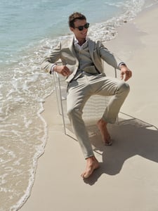 Groom with a bright suit on the beach