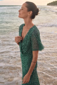 Brautmutter im grünen Kleid am Strand