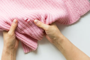 Loch auf der linken Seite eines pinken Pullovers