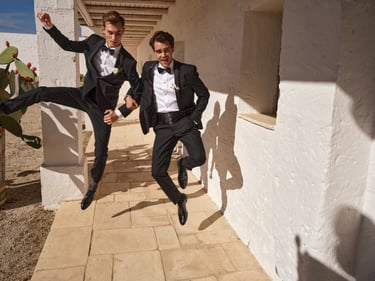Jumping groom with his friend in suits