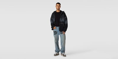 Mann in einer hellen Baggy Jeans mit Print