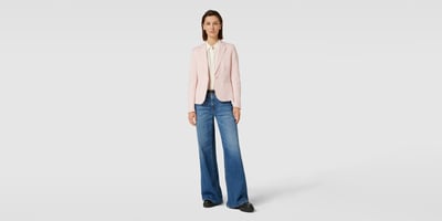 Frau in rosa Blazer und Flare Jeans