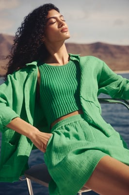 Frau in grünem Outfit aus Blazer und Shorts