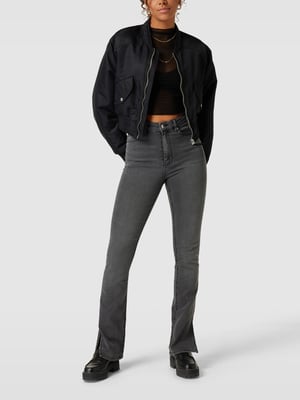 Graue Bootcut Jeans mit schwarzer Bomberjacke und Boots kombiniert