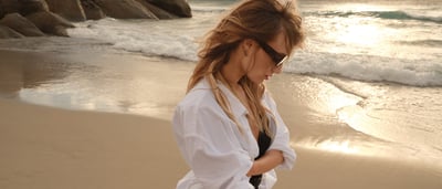 Frau mit einer Longbluse am Strand
