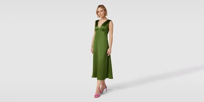 Frau mit grünem Kleid und pinken Sandaletten