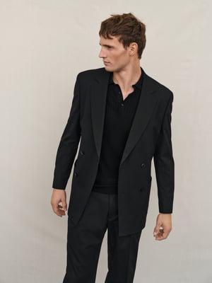Mann im schwarzen Anzug mit Poloshirt
