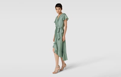 Frau mit grünem Kleid und silbernen Sandaletten 