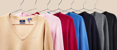 Verschillende kleuren truien op hangers