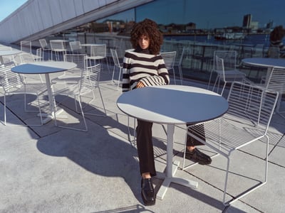 Vrouw in een zwart-witte trui op een terras