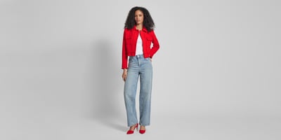 Frau in roter Jacke mit Jeans und roten Pumps