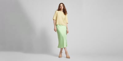 Kobieta w spódnicy i swetrze w pastelowych kolorach