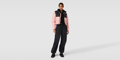 Frau in Tracking Outfit mit pinker Pufferjacke