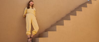 Frau in gelben Klamotten vor Treppe